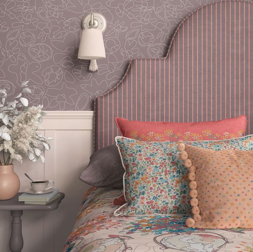 Bedroom pillows, bed headboard, and wallpaper mockup featuring floral and striped patterns in soft pastel colors.