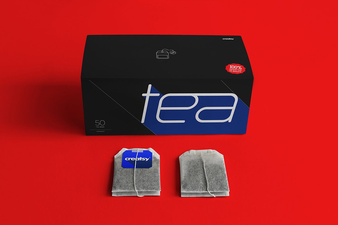 Tea box PSD mockup featuring a modern label design, placed next to two tea bags on a solid red tabletop.
