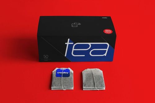 Tea box PSD mockup featuring a modern label design, placed next to two tea bags on a solid red tabletop.