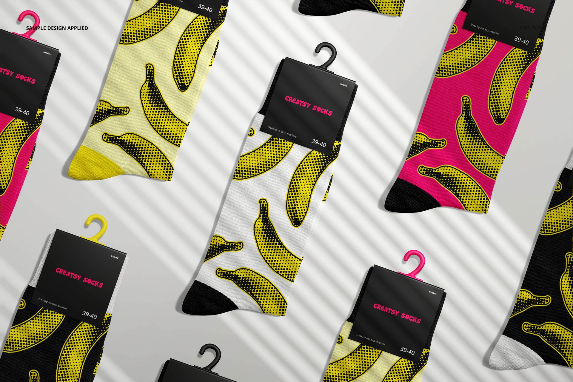 High cuff socks mockup featuring multiple pairs with banana patterns in yellow and pink, arranged on a light surface.