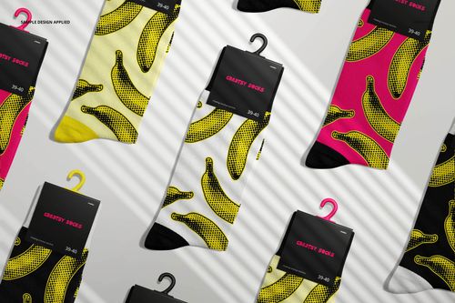 High cuff socks mockup featuring multiple pairs with banana patterns in yellow and pink, arranged on a light surface.