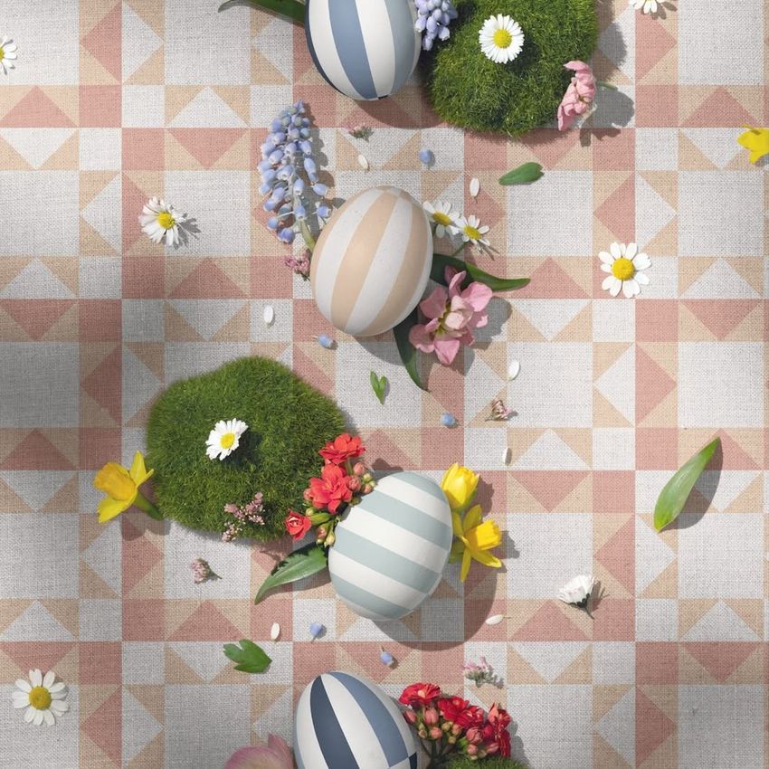 Easter mockup featuring striped eggs, moss lumps, and spring flowers arranged on a geometric patterned fabric background.