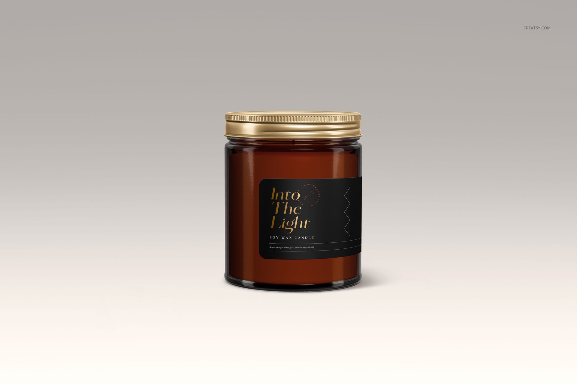 Front view of an amber jar candle mockup featuring a gold lid and dark label, set against a light gradient backdrop.