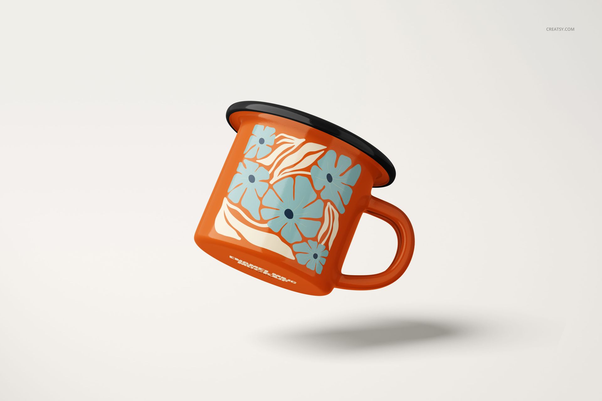 Orange enamel mug with blue floral pattern floating against a plain light background, shown in side view.
