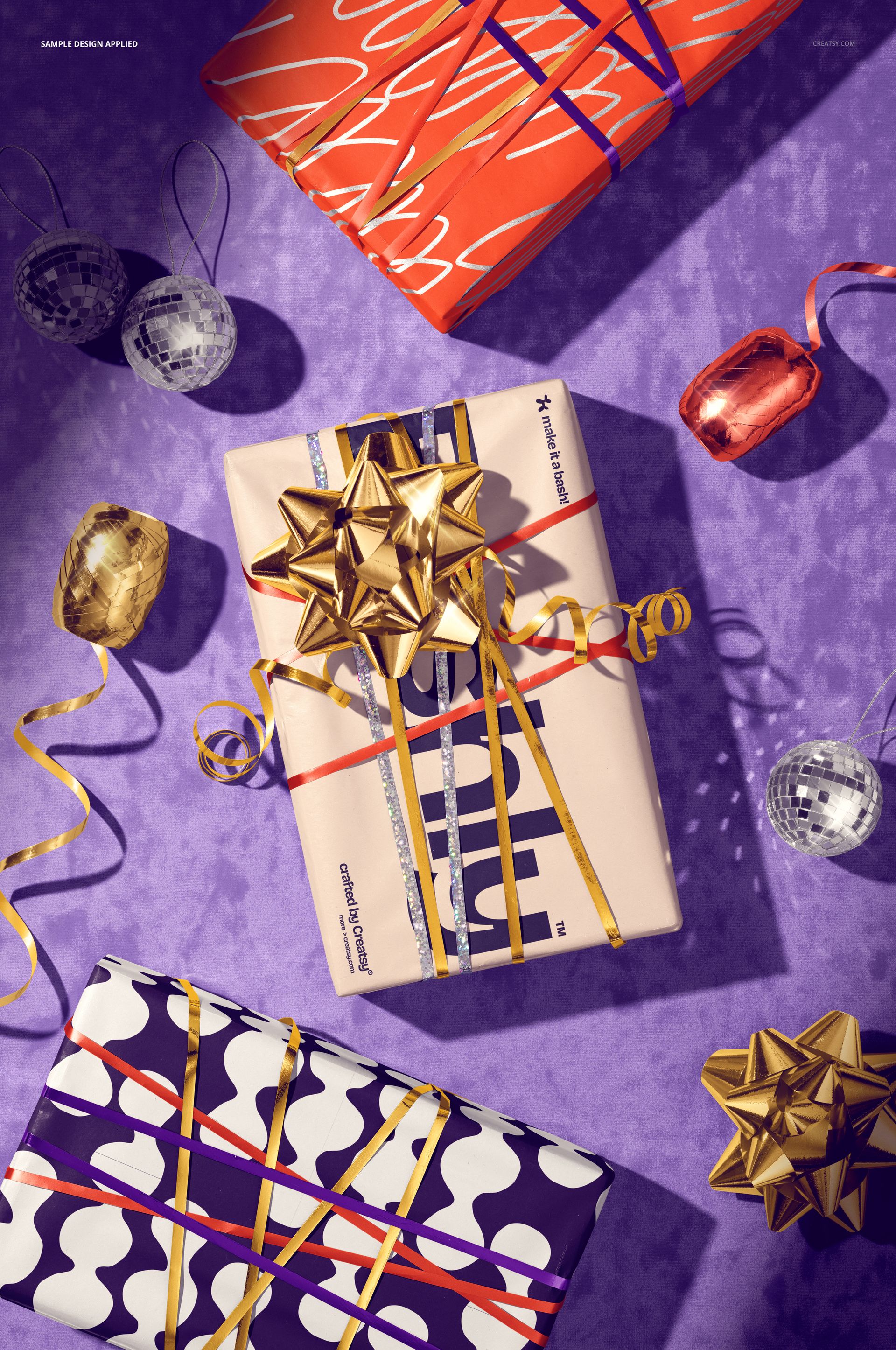 PSD mockup showing gift boxes with bold wrapping paper designs, gold ribbon accents, and festive props arranged on a purple backdrop.