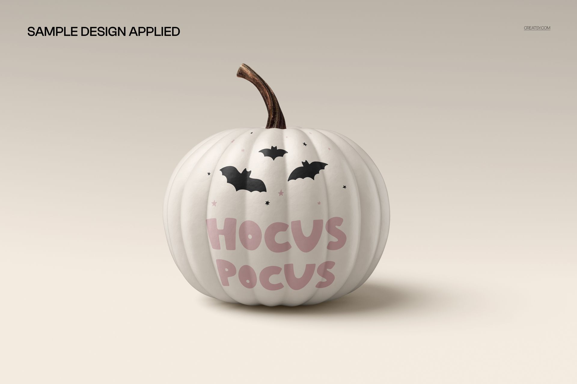 Front view of a white pumpkin with pink 'Hocus Pocus' text and black bat graphics, Halloween mockup scene.