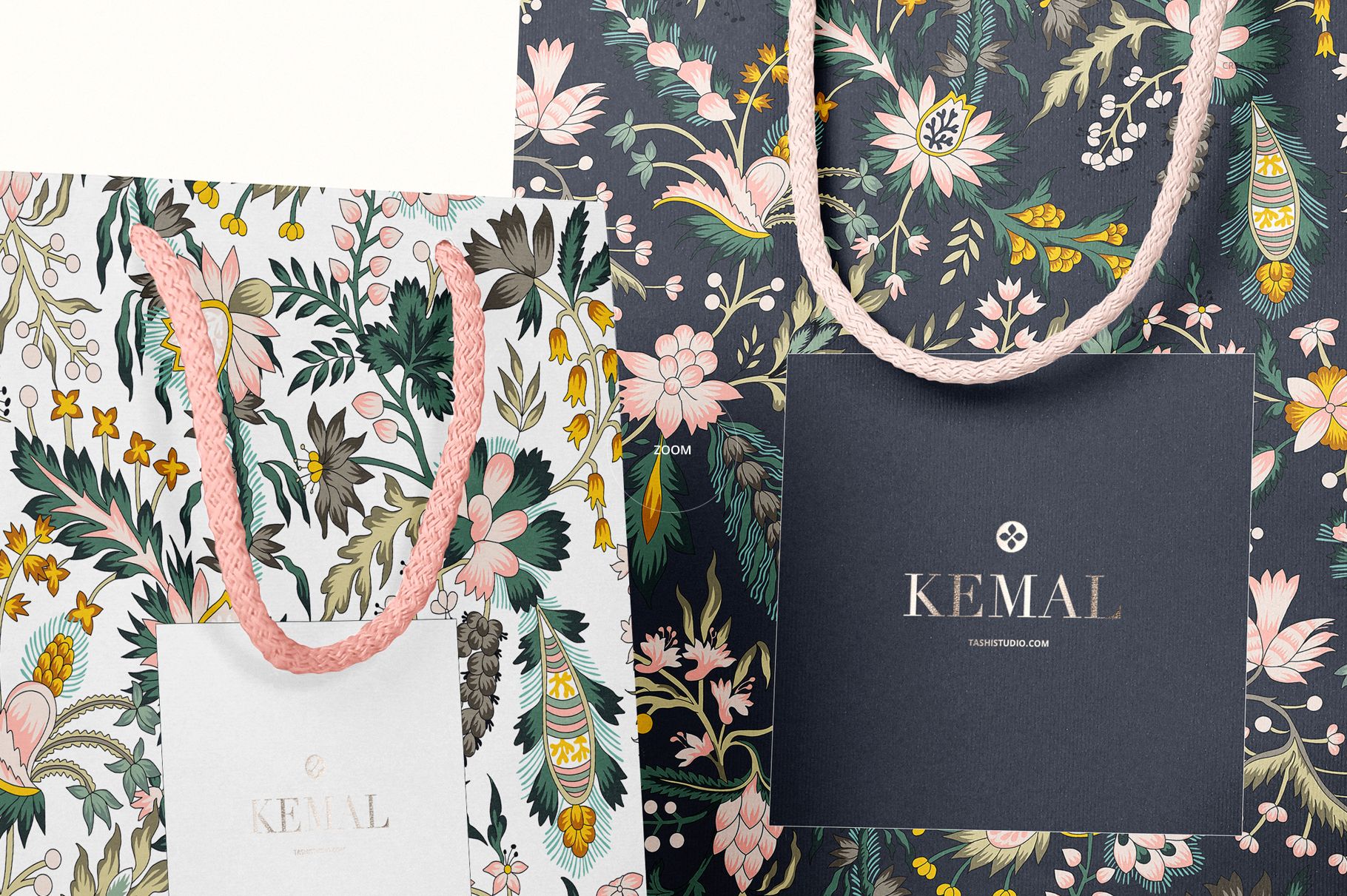 Two paper bags with floral patterns, one light and one dark, shown from the front with braided handles.