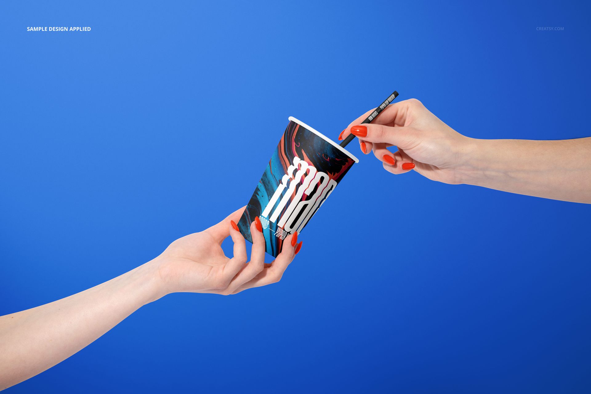 Close-up of a paper cup mockup being passed between two hands, with a vibrant pattern and blue backdrop.