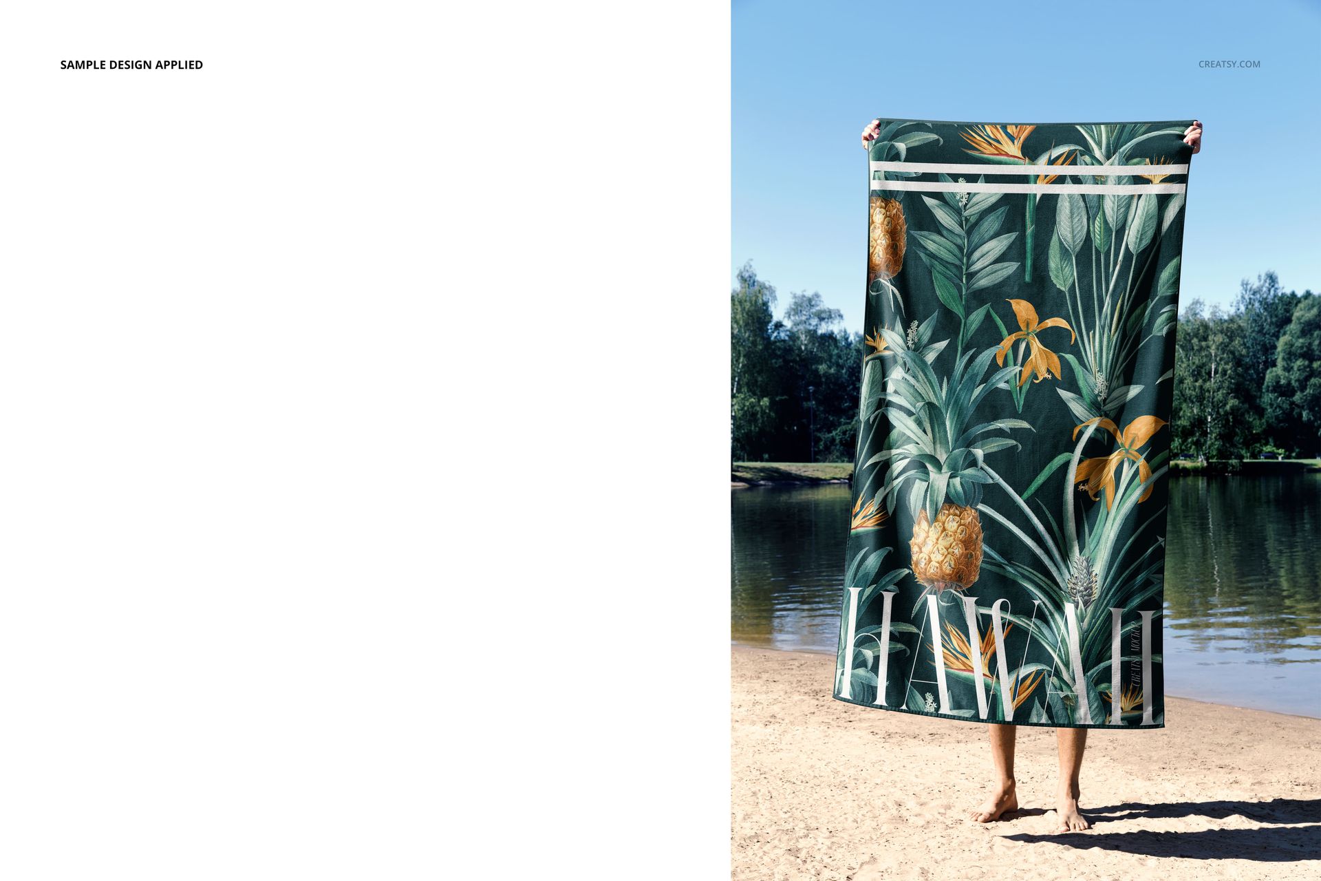 Front view of a beach towel mockup featuring a green botanical design, displayed outdoors by a lake.