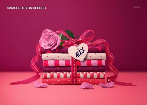 Fabric stack mockup featuring various pink and red patterns, velvet ribbon, rose, and heart tag, front view.