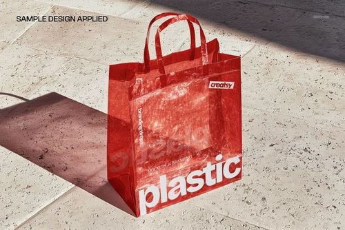 PSD mockup of a red semi-transparent plastic shopping bag with bold white text, shown in bright natural light.