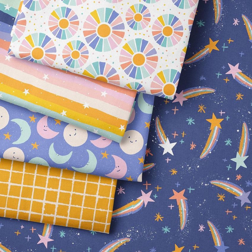 Folded fabrics mockup showing five colorful fabric pieces with playful patterns, including stars, moons, and geometric shapes.
