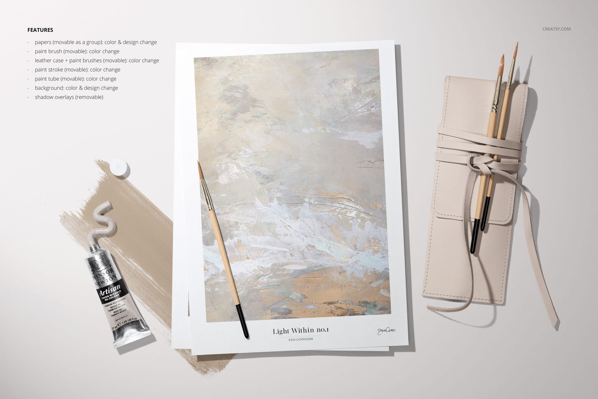 Art paper mockup with abstract painting, paintbrushes, paint tube, and beige leather case arranged on a light surface.