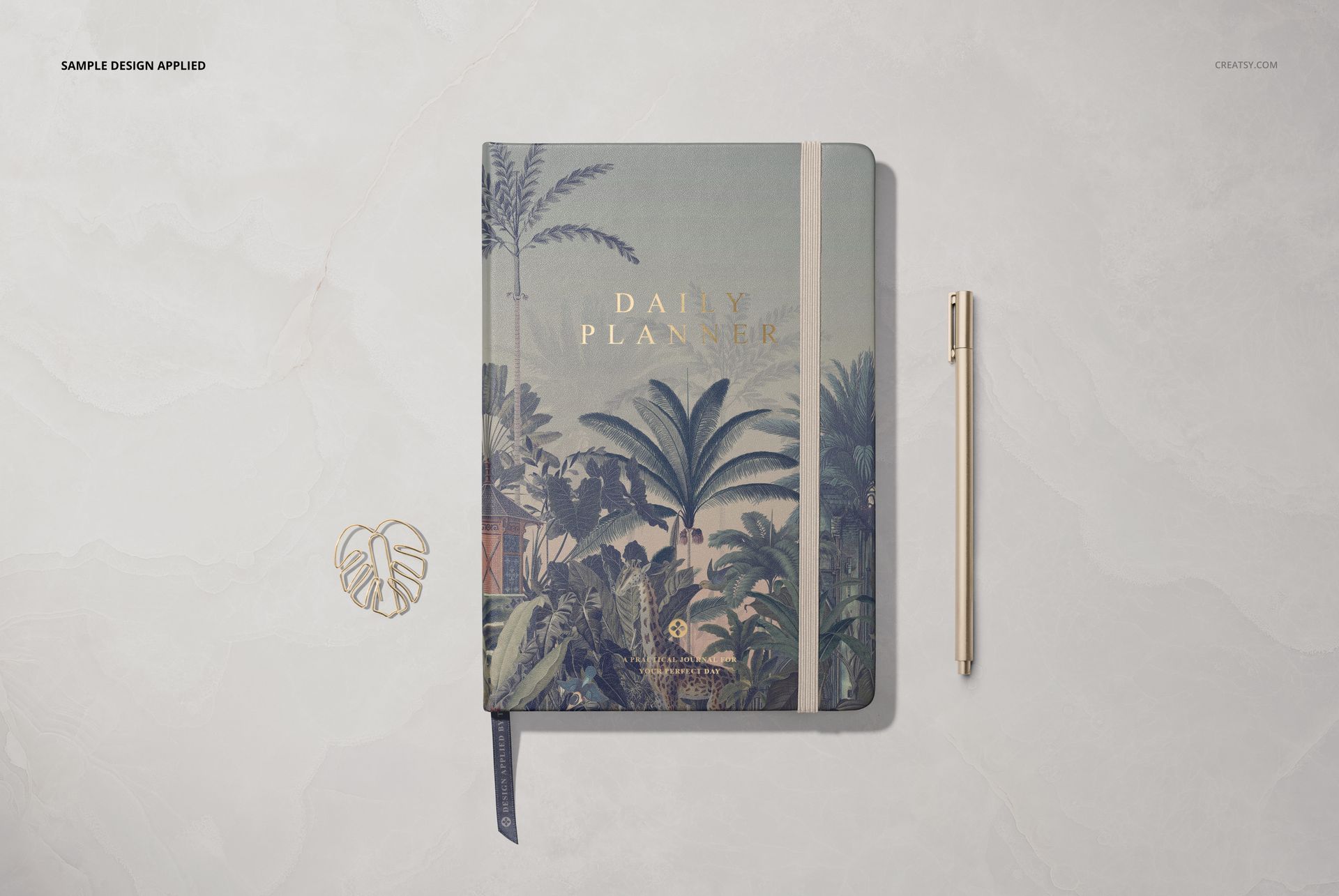 Top view of a leather notebook mockup featuring a botanical cover design, placed on a light marble background with a pen.