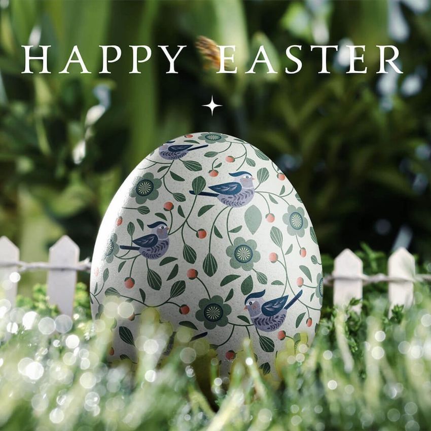 Easter egg card mockup showing a decorated egg with bird and floral patterns, set outdoors with greenery and a white picket fence.
