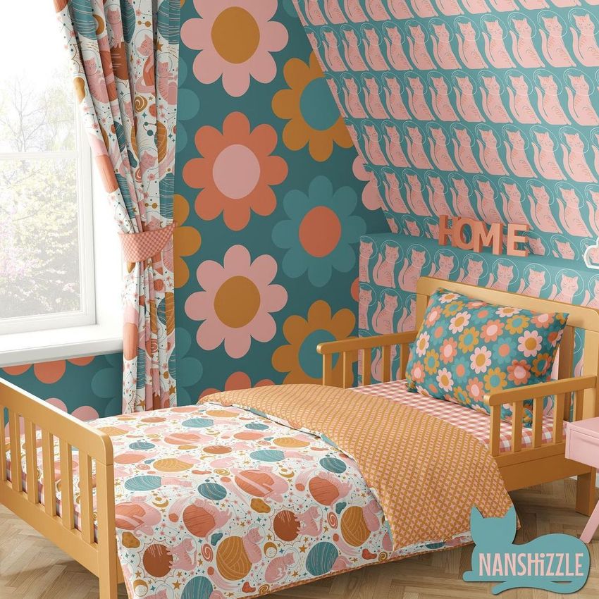 Toddler room bedding mockup showing a wooden bed with patterned bedding, floral and cat-themed wallpaper, and matching curtains.