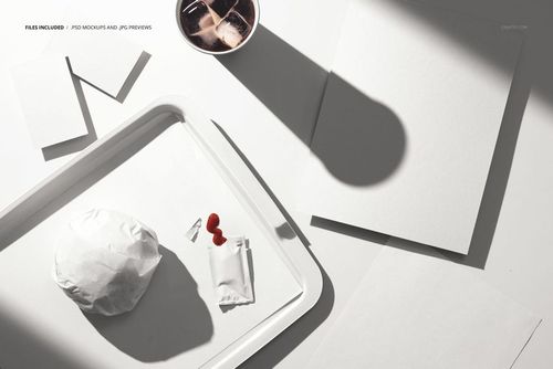 Fast food tray mockup featuring a wrapped sandwich, condiment packets, blank flyers, and a beverage cup in sunlight.