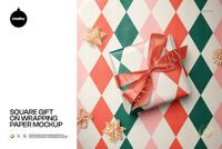 Christmas PSD mockup featuring a square gift box with a decorative bow atop red and green diamond patterned paper.