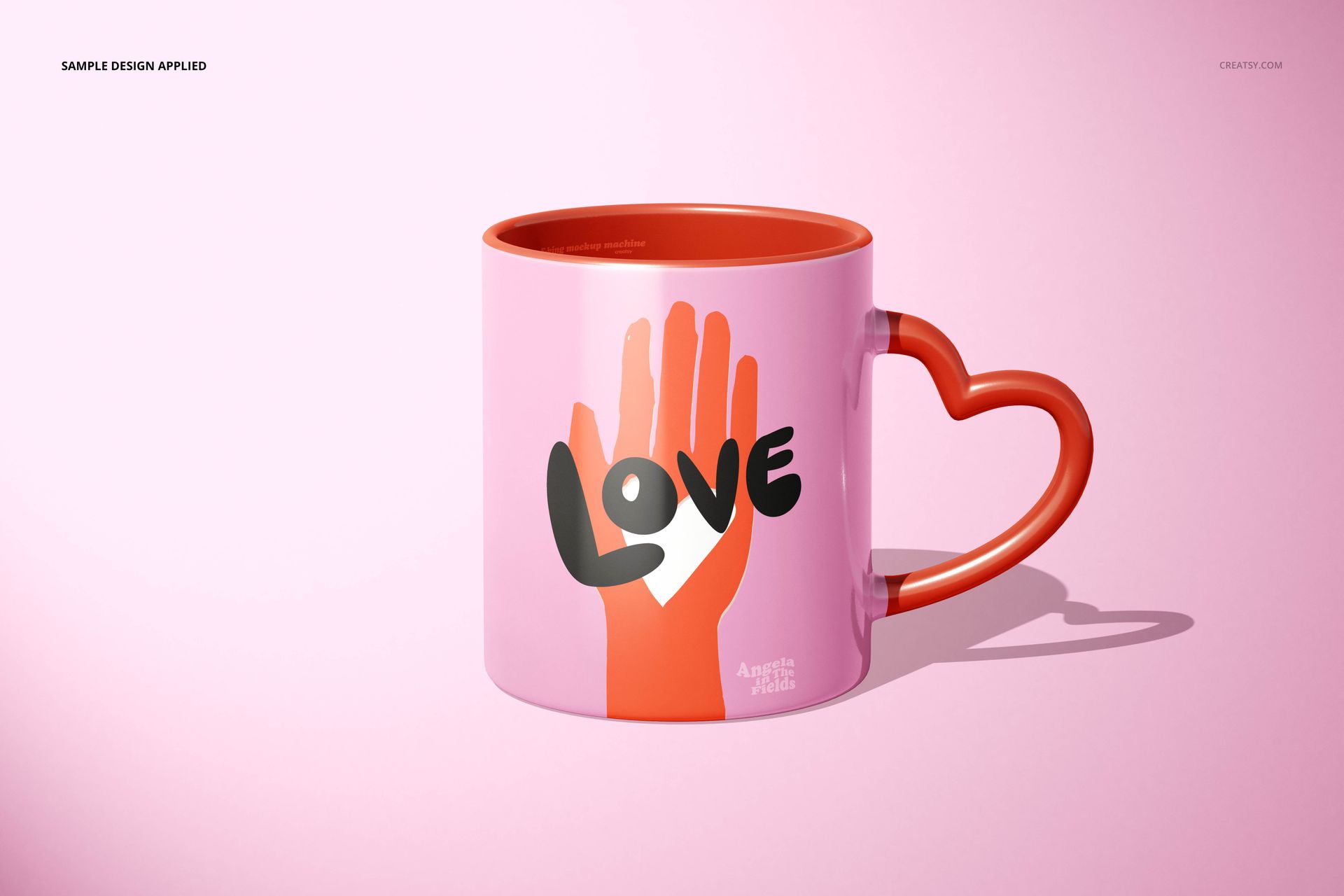 PSD mockup of a ceramic mug with heart-shaped handle, pink body, orange accents, and a stylized graphic design on the front.