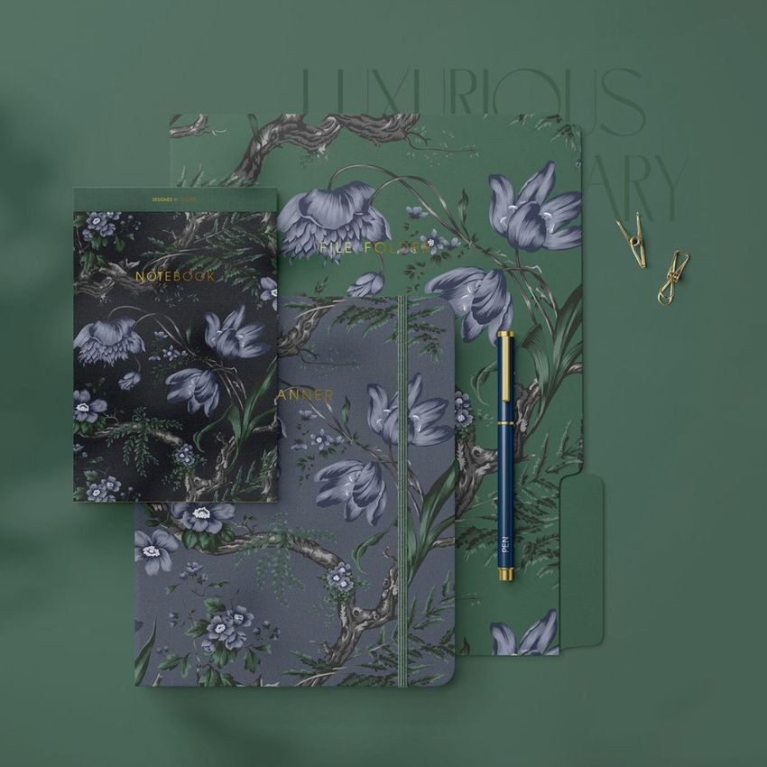 Stationery mockup featuring a notebook, planner, and folder with elegant floral patterns in green and gray tones on a green surface.