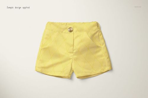 Front view of yellow baby shorts with a subtle diamond pattern, displayed on a light background in a mockup scene.
