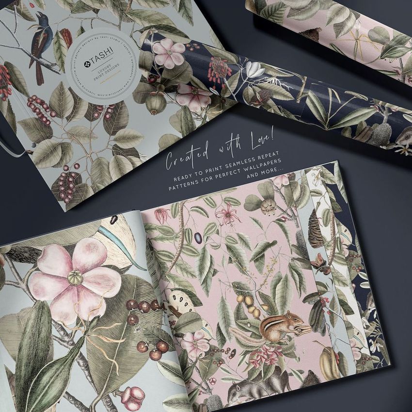 Wallpaper sample book mockup featuring botanical illustrations with birds, flowers, and leaves, shown with rolled wallpaper samples.