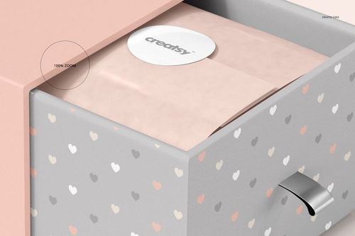 PSD mockup showing a gray gift box with pastel hearts, open to reveal pink tissue paper and a round label on top.