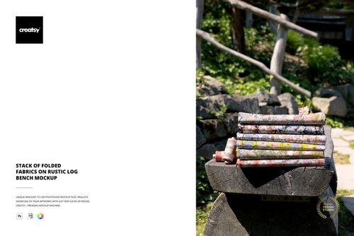 PSD mockup showing a pile of colorful fabric pieces arranged on a log bench, with natural stones and plants nearby.