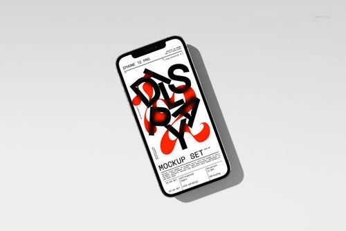 Angled top view of an iPhone 12 Pro with a mockup design on the screen, casting a soft shadow on a plain surface.