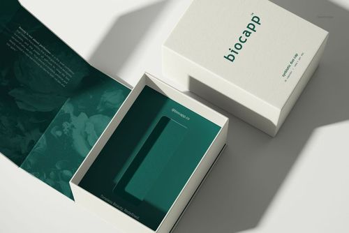 Premium packaging mockup showing a box with a fitted insert tray, white exterior and green inner details.