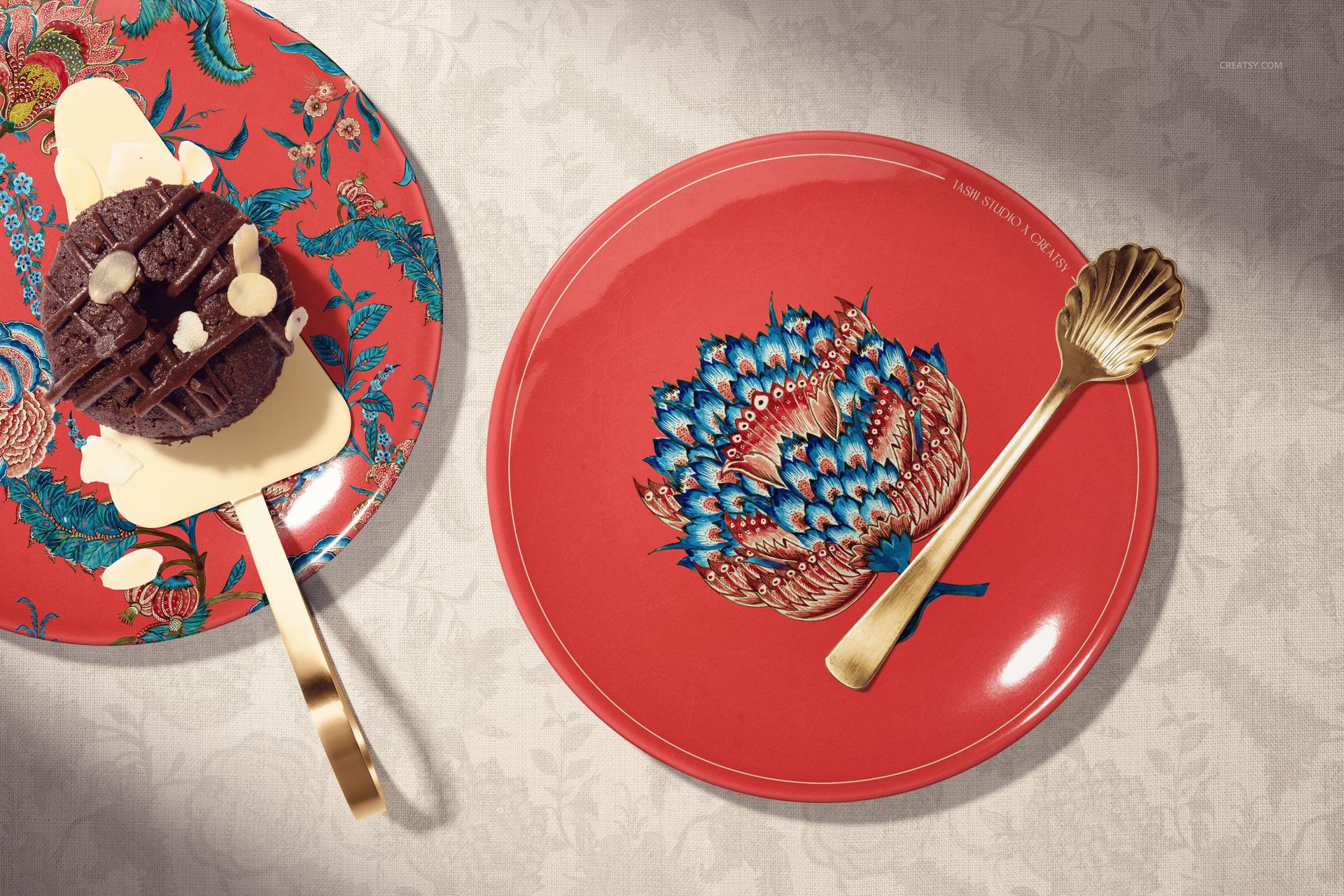 PSD mockup featuring round ceramic plates in red with ornate blue motifs, styled with a gold fork and decorative dessert.
