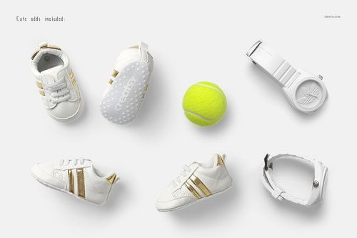 White and gold baby shoes, a yellow tennis ball, and two white wristwatches arranged on a light background.
