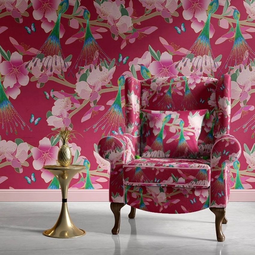 Retro velvet armchair mockup in a living space with pink floral and bird patterns on both the chair and wallpaper background.