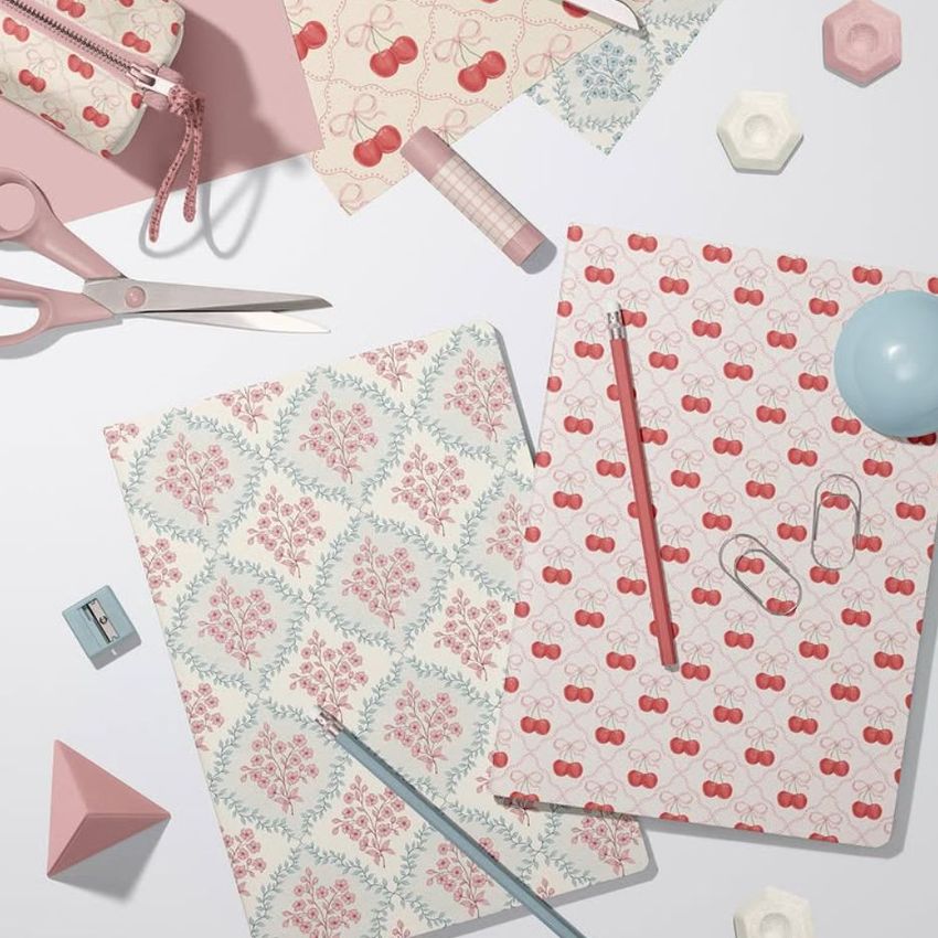 Stationery mockup featuring two A4 notebooks with vintage floral and cherry patterns, surrounded by pastel office supplies.