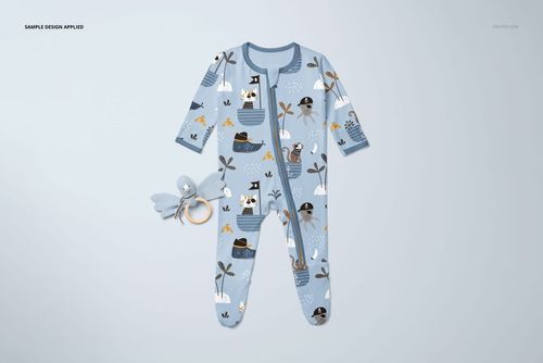 PSD mockup of a blue baby onesie with cartoon animal pirates and ships, laid flat alongside a cuddly duck toy on a pale surface.