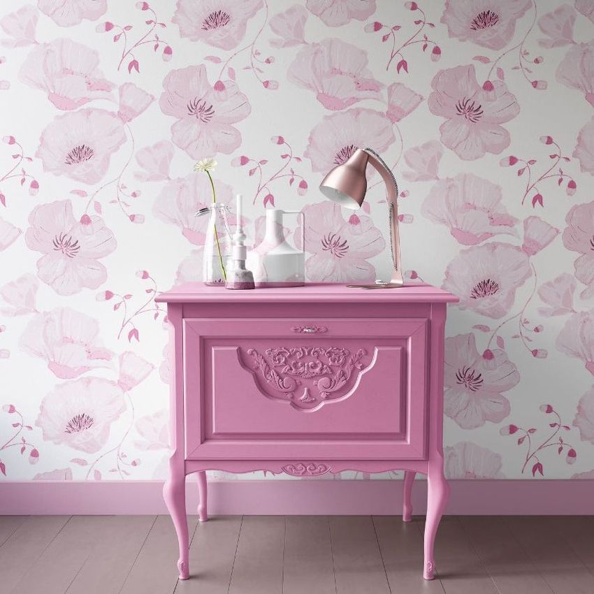 Interior scene mockup showing a pink vintage nightstand in front of a wall with large pink poppy flower patterns and decorative items on top.