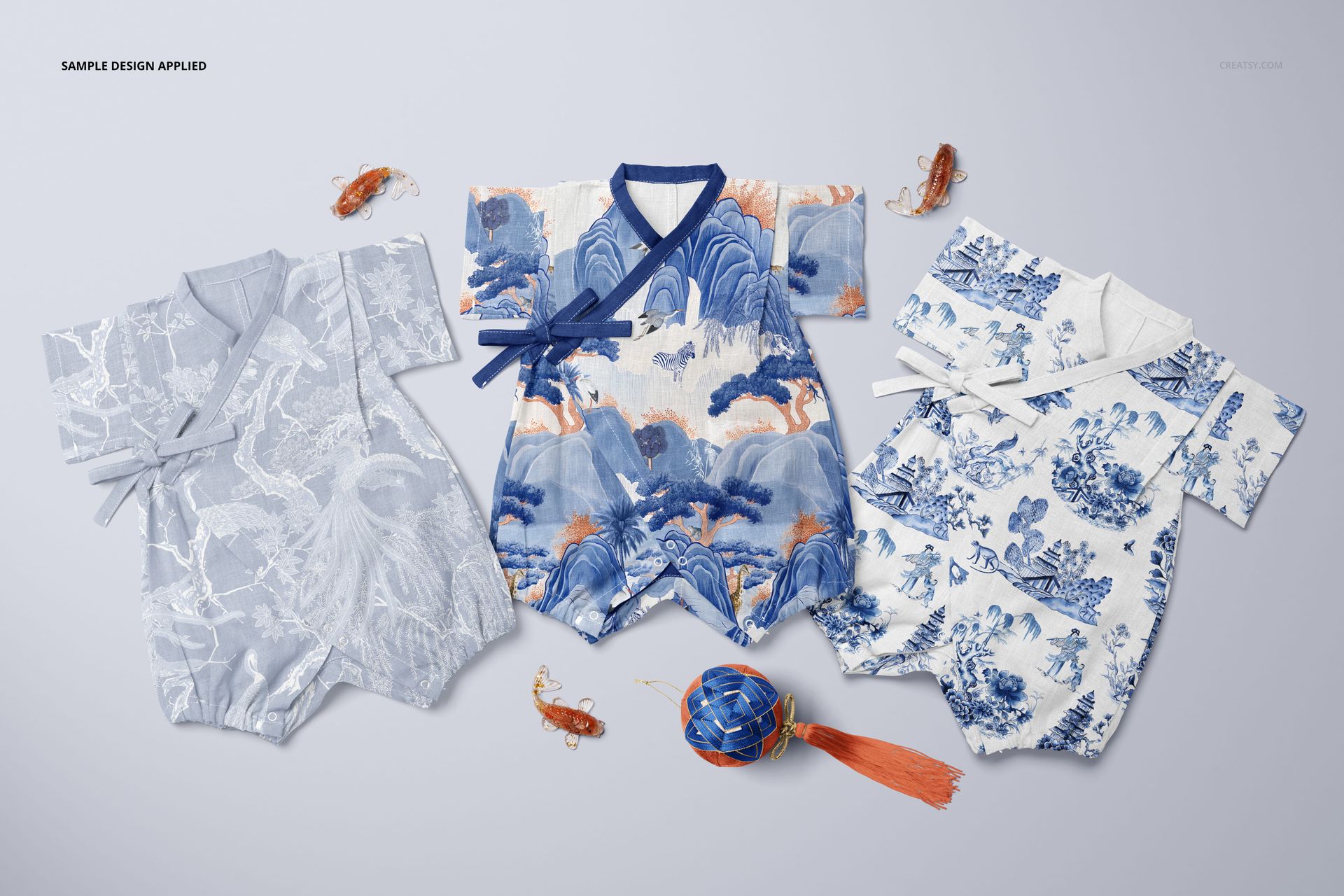 PSD mockup showing three Japanese baby rompers with traditional blue prints, arranged with small decorative items.