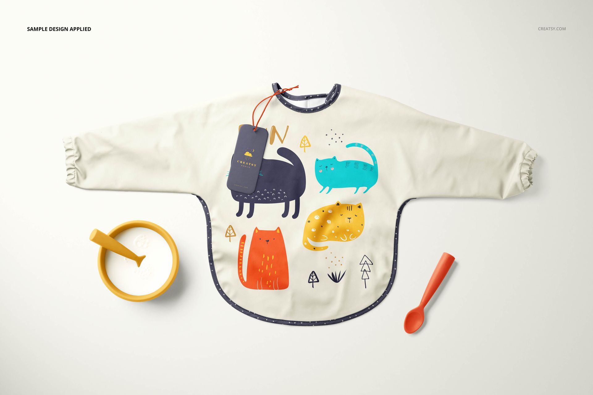 Baby sleeved bib mockup featuring a cream-colored bib with playful animal illustrations, shown from a top view.