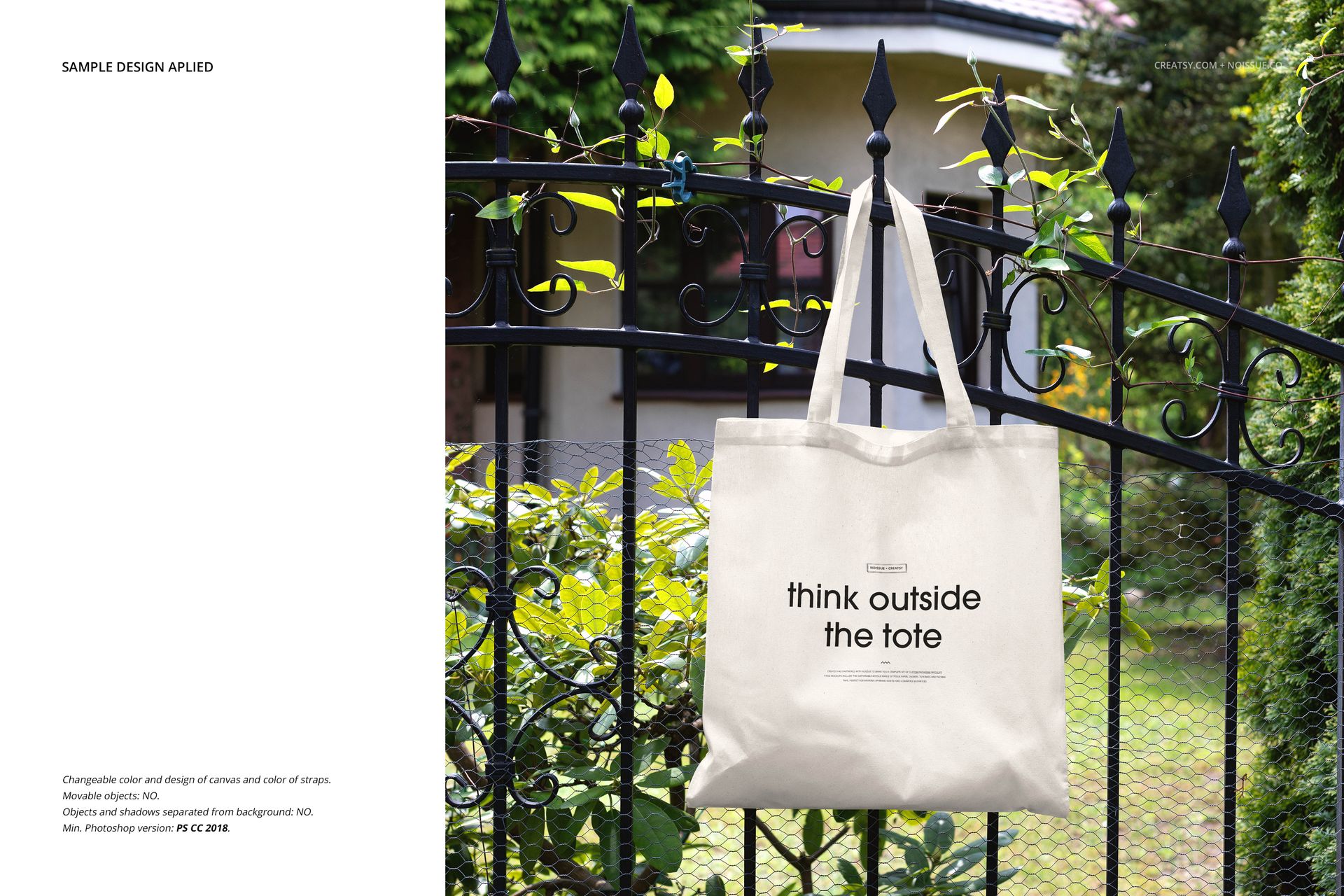 Front view of a plain tote bag mockup displayed on a decorative metal fence with lush greenery in the background.