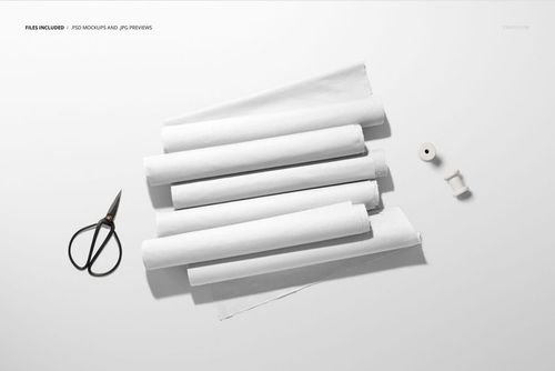 PSD mockup showing multiple white fabric rolls, some slightly unrolled, with sewing tools placed nearby.