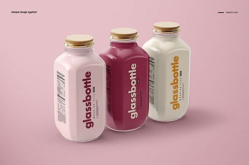 Glass bottle PSD mockup set showing three jars with gold lids, varied label colors, and simple branding against a pink backdrop.