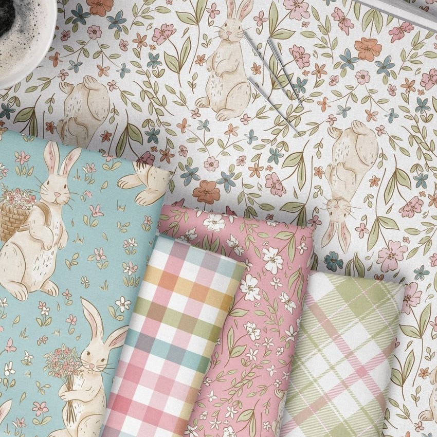 Folded fabrics mockup featuring pastel patterns with bunnies, flowers, and plaid designs arranged on a floral background.