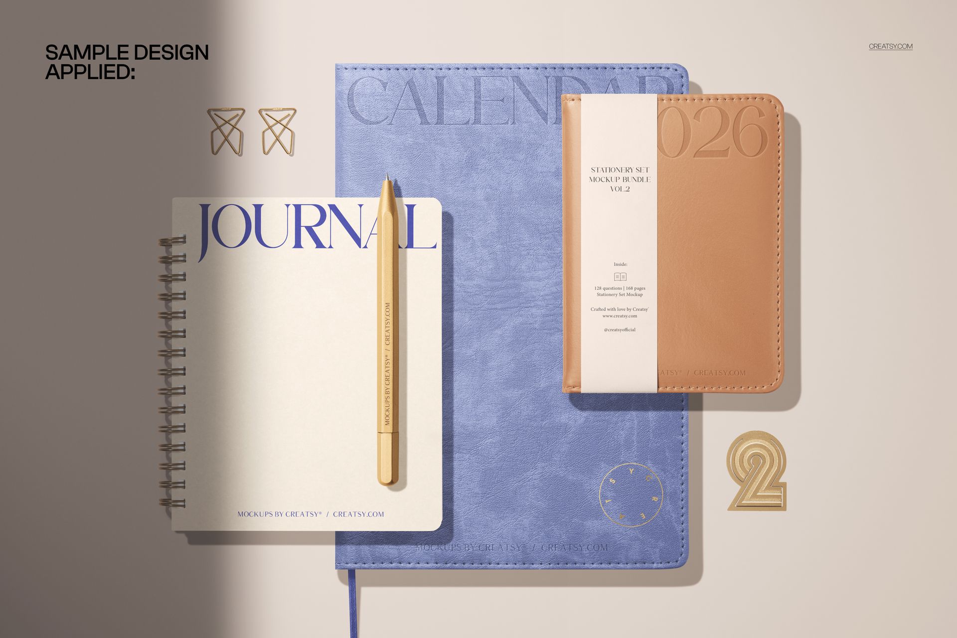 Stationery mockup featuring a spiral-bound journal, large blue calendar, and tan pocket calendar seen from above.