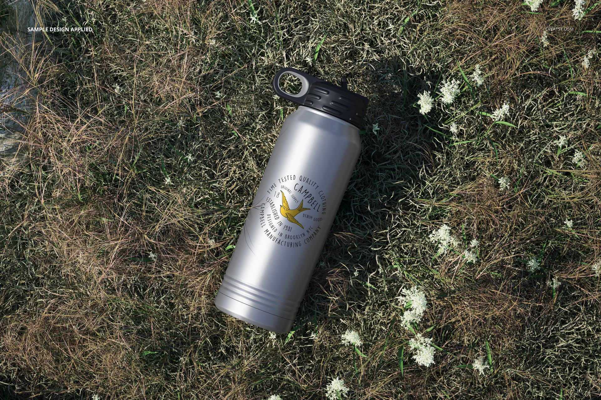 Metallic 30 oz. water bottle mockup with black screw cap, placed outdoors on patchy grass, logo visible on front.