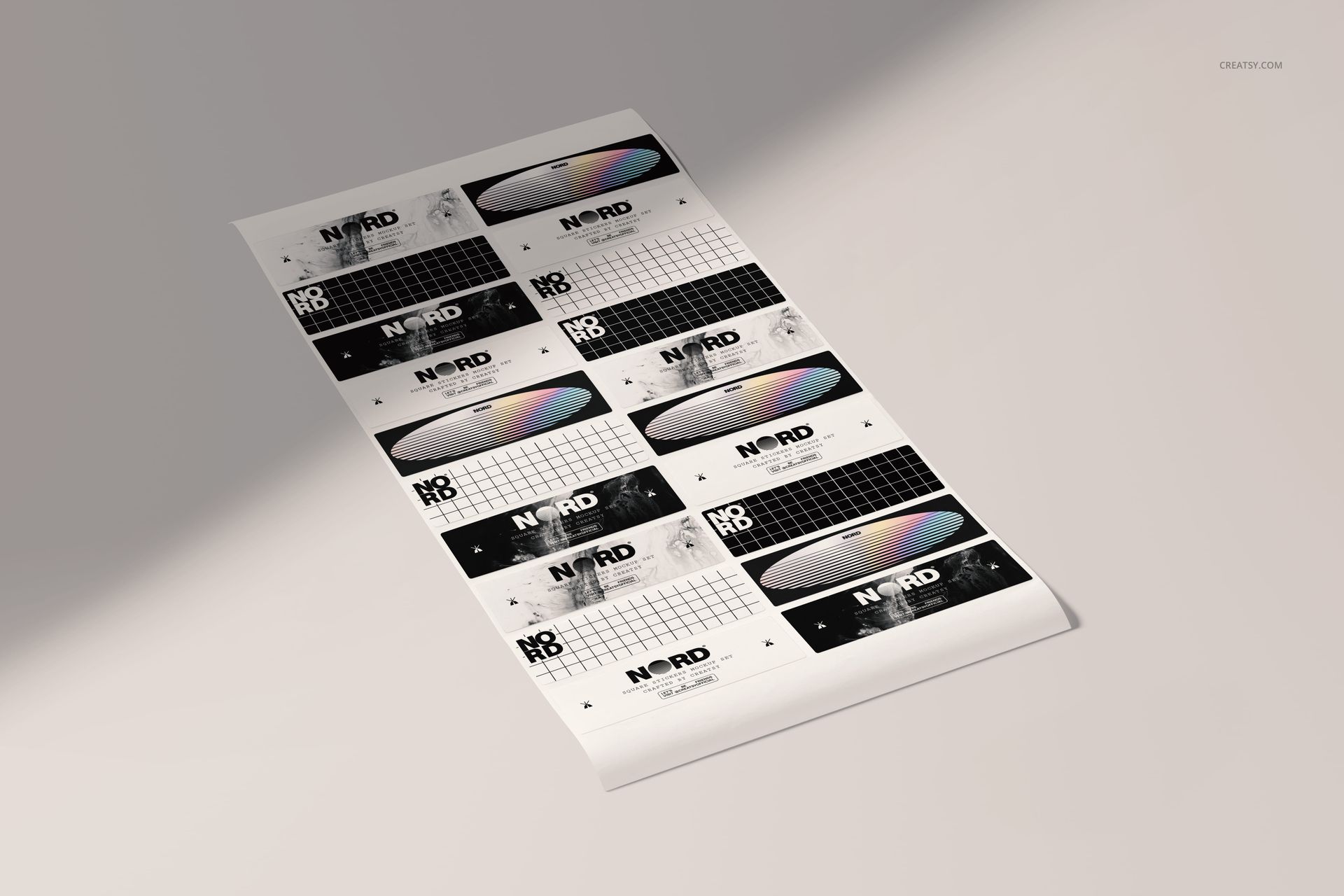 Rectangular sticker mockup set displayed on a light surface, showing varied black, white, and rainbow-toned graphics.