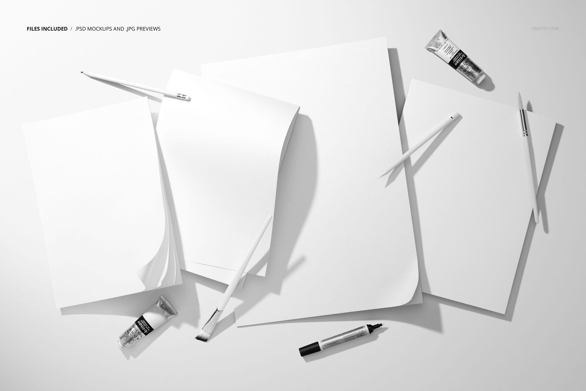 Group of empty paper pads displayed with art supplies including paint tubes and drawing tools in a PSD mockup scene.