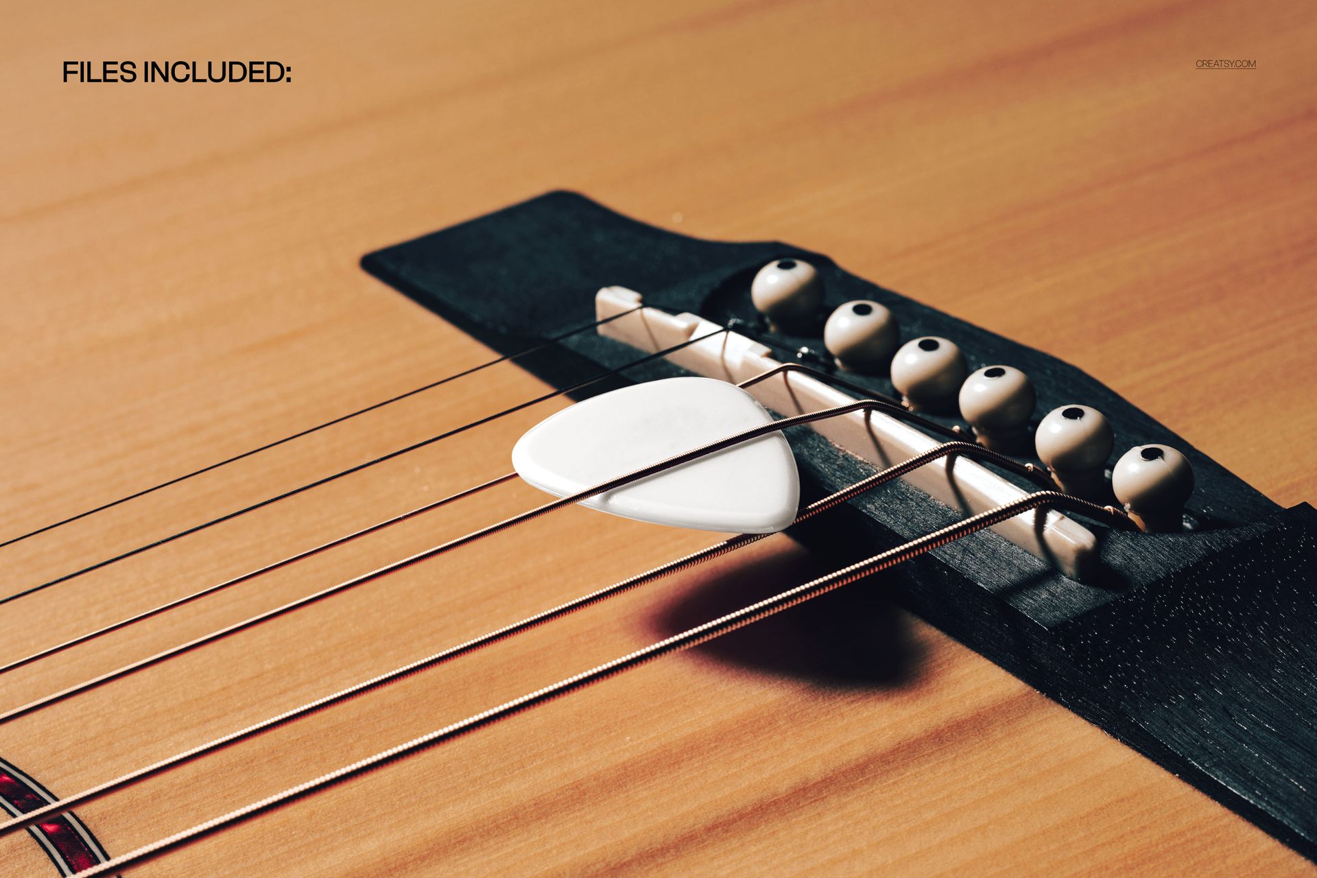 PSD mockup featuring a guitar pick positioned on the bridge of an acoustic guitar, highlighting wood grain and strings.