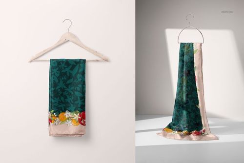 Green patterned silk scarf with colorful floral accents draped on a hanger, shown in a fashion accessory mockup scene.