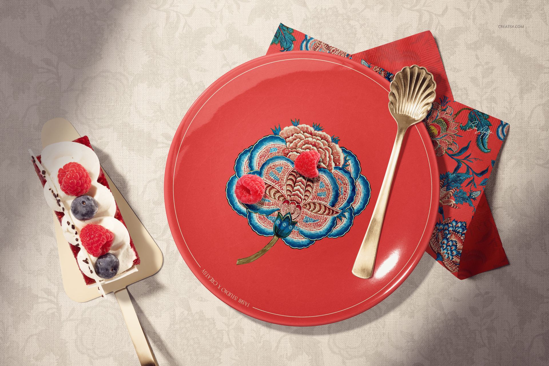 Ceramic plate mockup featuring a red plate with embroidered floral motif, dessert, and decorative napkin.