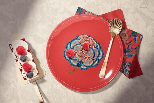 Ceramic plate mockup featuring a red plate with embroidered floral motif, dessert, and decorative napkin.